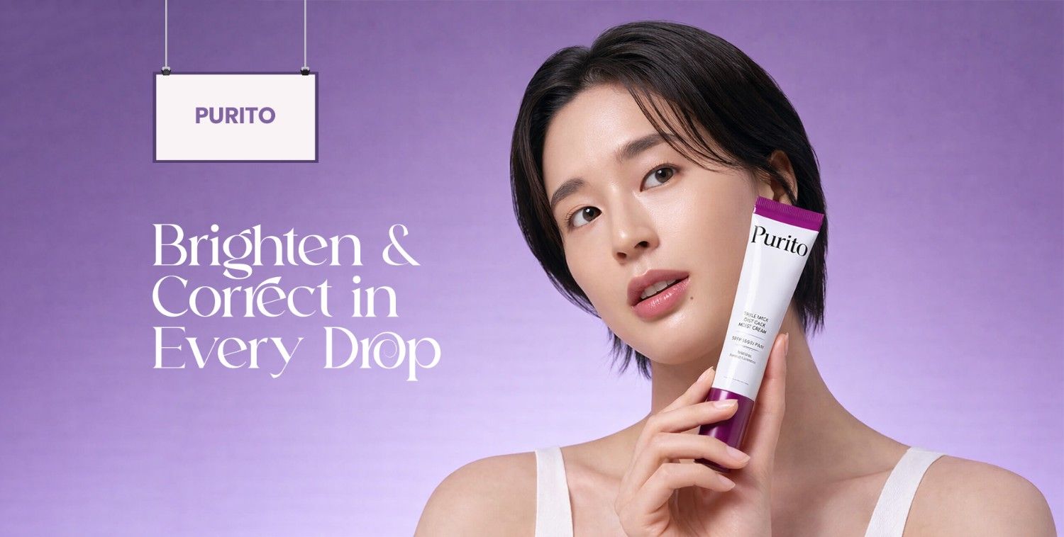 Woman with short dark hair holding a Purito cream tube against a vibrant purple background.