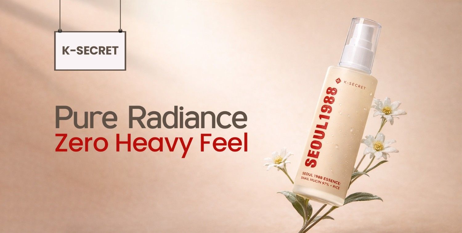 K-Secret "Pure Radiance Zero Heavy Feel" essence bottle with white flowers on a soft, natural background.