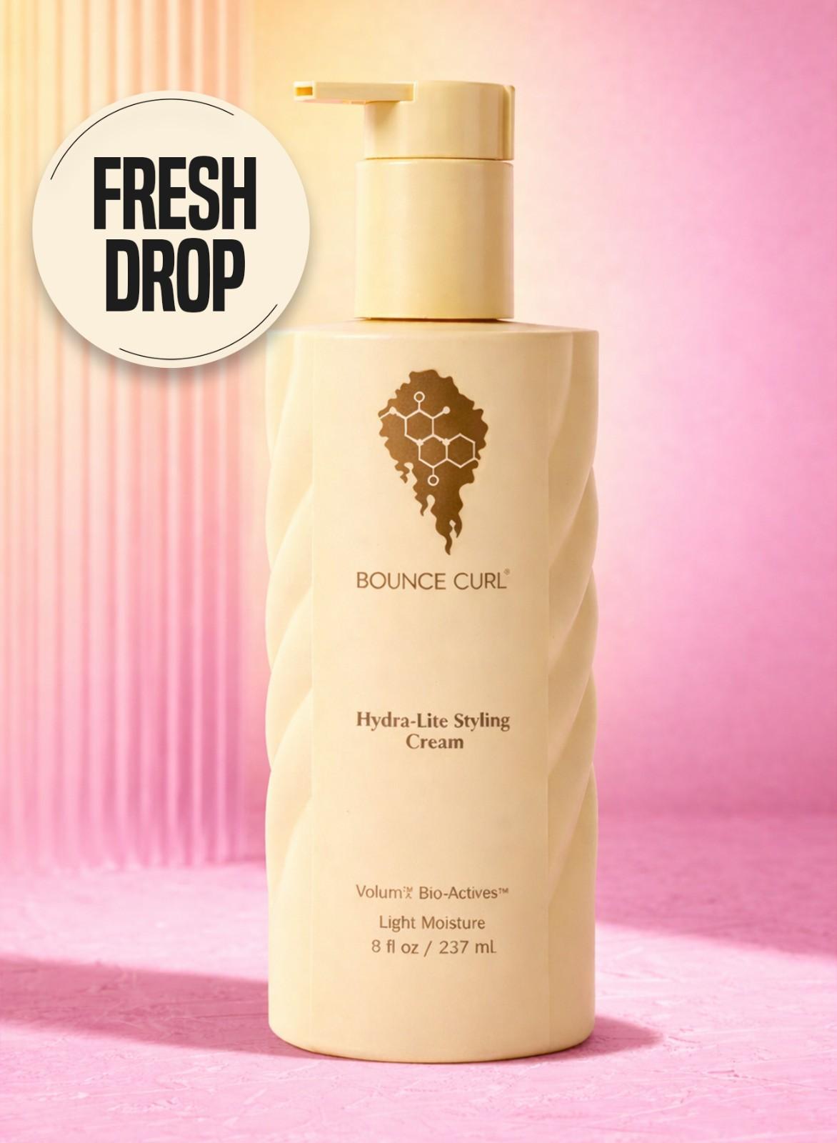 Bottle of Bounce Curl Hydra-Lite Styling Cream on a pink background with 'Fresh Drop' text.