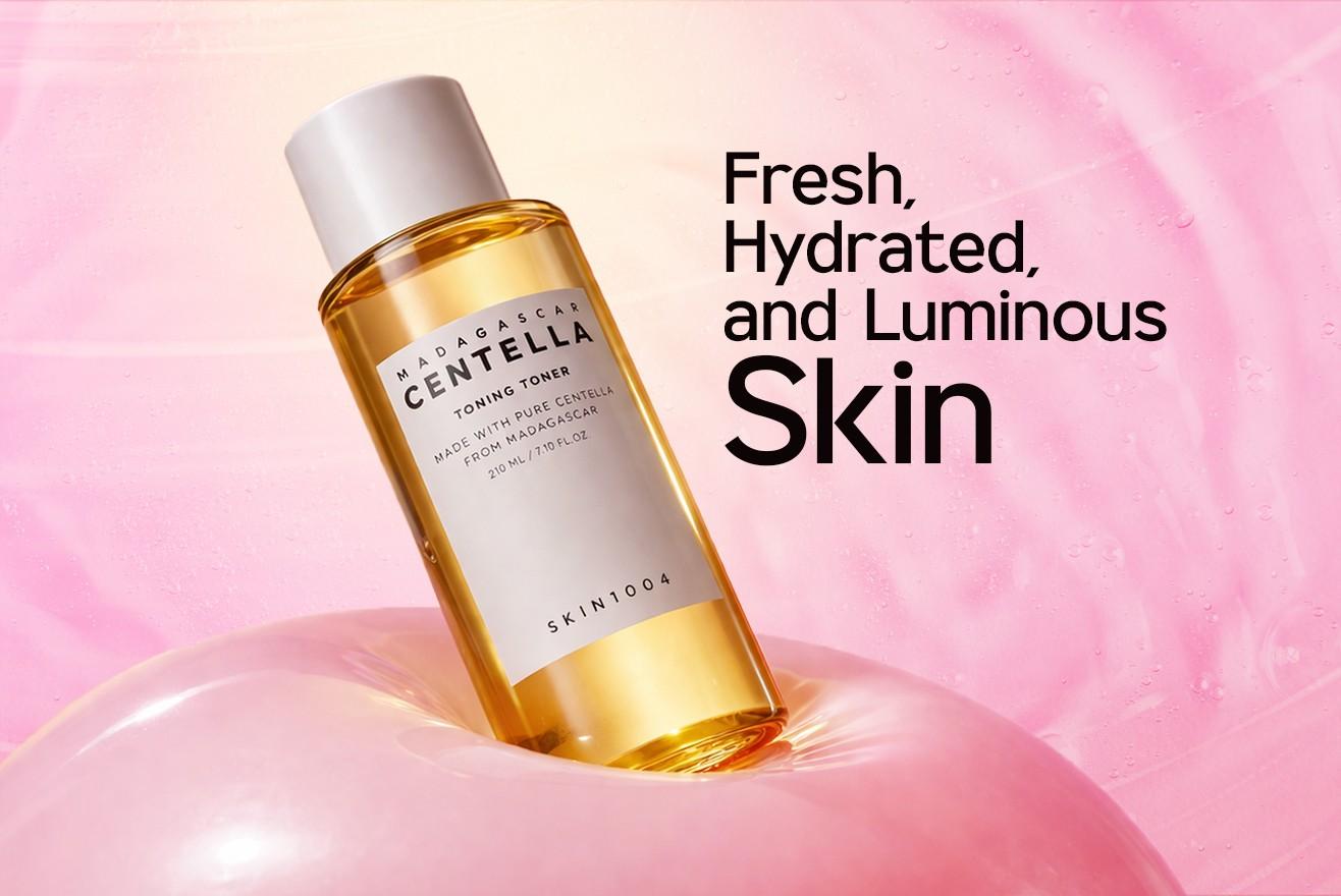 Skincare bottle with text 'Fresh, Hydrated, and Luminous Skin' on a pink background