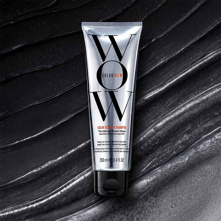 Silver tube of WOW Color Shampoo on a textured black background